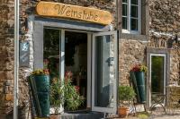 een bord op de deur van een gebouw met planten bij Ferienweingut Niessner in Ernst