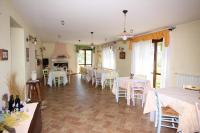 una sala da pranzo con tavoli bianchi e sedie bianche di Agriturismo L'Arcadia a Città Sant'Angelo