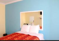 Un dormitorio con una cama con un espejo grande. en Plaza Hotel Gardena, en Gardena