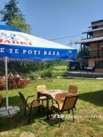 een tafel en stoelen onder een paraplu in een veld bij Pensiunea La Taverna in Trăisteni