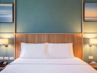 a bedroom with a bed and two lamps and a phone at Ibis Phuket Patong in Patong Beach