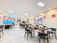 uma sala de jantar com mesas e cadeiras em um restaurante em 头等舱国际酒店-成都天府机场店 em Jianyang