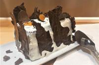 a chocolate cake on a plate next to a knife at Ets CAPMASIL - chambre 1920 in Virac