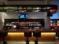 a bar with a television above a bar with stools at Autentico Monterrey in Monterrey