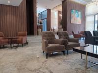 Una zona de espera con sillas y mesas en un vestíbulo. en Executive Boutique Hotel Rabat, en Rabat