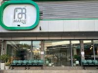 Un escaparate de un centro comercial con sillas verdes. en Marni BKK Hostel, en Bangkok