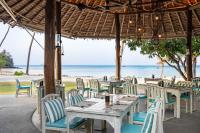 Un restaurante con mesas y sillas en la playa. en SAii Phi Phi Island Village, en Islas Phi Phi