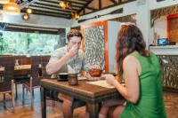 a man and a woman sitting at a table in a restaurant at Daluyon Beach and Mountain Resort in Sabang