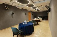 Una sala de reuniones con dos mesas y sillas verdes. en CMK HABITAT CENTRE, en Ernakulam