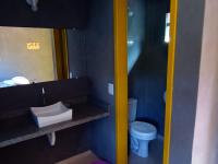 a bathroom with a toilet and a sink and a mirror at Pousada ZEN Cumuruxatiba in Cumuruxatiba