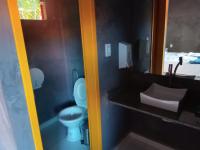 a bathroom with a toilet and a sink and a mirror at Pousada ZEN Cumuruxatiba in Cumuruxatiba