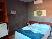 a bedroom with a bed with a blue blanket at Pousada ZEN Cumuruxatiba in Cumuruxatiba