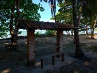 a brick shelter with a bench in a park at Pousada ZEN Cumuruxatiba in Cumuruxatiba