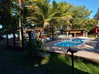 a swimming pool in a yard with a palm tree at Pousada ZEN Cumuruxatiba in Cumuruxatiba