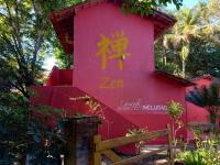 a pink building with a sign on it at Pousada ZEN Cumuruxatiba in Cumuruxatiba