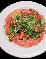 un piatto bianco con una pizza con verdure sopra di Ferienwohnungen Lehnerwirt a Breitenbrunn