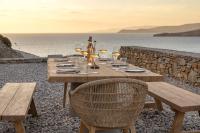 Una mesa de madera con copas de vino en una playa. en Yfes, en Kithnos