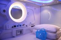 a room with a bed and a round window at Hey Bear Capsule Hotel in Taipei