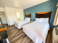 2 Betten in einem Zimmer mit blauen Wänden und Holzböden in der Unterkunft Town and Country Inn in Santa Barbara