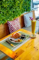 una mesa con un plato de comida y un vaso de jugo de naranja en UNOTEL Karon Beach, en Karon Beach