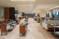 Un restaurante con mesas de madera y sillas azules. en Fairfield by Marriott Jodhpur, en Jodhpur