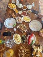 Una mesa de madera cubierta con muchos tipos diferentes de comida. en Hotel Riverside Inn, en Martuni