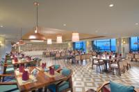 Un restaurante con mesas y sillas de madera y ventanas. en Treat Hotel Nashik City Center, en Nashik