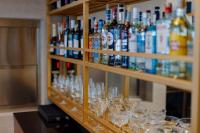 Una fila de vasos en un estante con botellas. en Piazza Epigraph, en Batumi