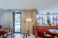 Un restaurante con un sofá rojo y mesas y sillas. en Piazza Epigraph, en Batumi