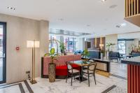 Un vestíbulo con un sofá, una mesa y sillas. en Piazza Epigraph, en Batumi