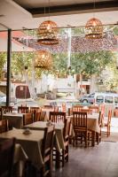 Un restaurante con mesas, sillas y luces. en Hotel El Sauce, en Santa Rosa de Calamuchita