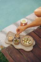a person reaching for a bowl of food on a table at Koloa Concept Hotel in Barra Grande