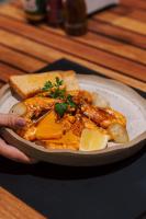a person holding a plate of food on a table at Koloa Concept Hotel in Barra Grande