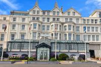 un gran edificio blanco con una estatua delante de él en The Empress Hotel, en Douglas