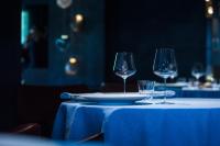 Una mesa con dos copas de vino y un plato encima. en Le Hameau Albert 1er - Relais & Châteaux, en Chamonix-Mont-Blanc