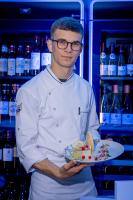 サン・ディエにあるLogis Hôtel Le Régal & Spaのホットドッグが乗った皿を持っている男性