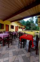 ein Restaurant mit Tischen und Stühlen und einem roten Tisch in der Unterkunft Pousada Sítio Monte Sinai in São José do Barreiro