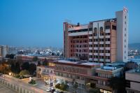 Un edificio alto con un cartel al costado. en Ramada by Wyndham - Sulaymaniyah Salim Street, en As Sulaymānīyah