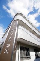 Un edificio con un cartel en el costado. en Hotel Imalle Haneda, en Kawasaki