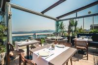 ein Restaurant mit Tischen und Stühlen auf einem Balkon in der Unterkunft Tiara Buyukada in Büyükada