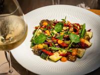 un plato blanco con ensalada y una copa de vino en Es Figueral Nou Hotel Rural & Spa - Adults Only - Over 12, en Montuiri