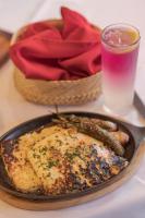 una mesa con un plato de comida y un vaso de agua en Hotel Santa Anita - Balderrama Hotel Collection, en Los Mochis