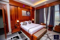 Un dormitorio con una cama y una silla dentro. en Royal Mgwasi Hotel, en Mbeya