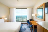 Una habitación de hotel con una cama y un escritorio con un escritorio en Noah&#39;s On the Beach, en Newcastle
