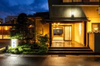 a building with stairs leading to a door at night at Ryokan Marumo in Tottori