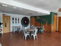 ein Esszimmer mit Tischen, Stühlen und einer Wand in der Unterkunft El Molino Hostal-Restaurante in Jarafuel