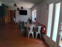 ein Esszimmer mit Tisch und Stühlen und einem Fernseher in der Unterkunft El Molino Hostal-Restaurante in Jarafuel