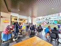 a group of people sitting at tables in a restaurant at Bali Residence Waterpark Executive Suites Melaka By GGM in Melaka