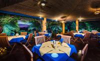 a restaurant with blue tables and chairs and trees at Boutique Hotel Luna Azul in Playa Ostional