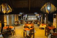 穆龙达瓦Hôtel Baobab Café的一家有桌椅和酒吧的餐厅